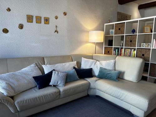 a living room with a couch with blue and white pillows at T3 Chaleureux - Vieux Toulon - Proche Port in Toulon
