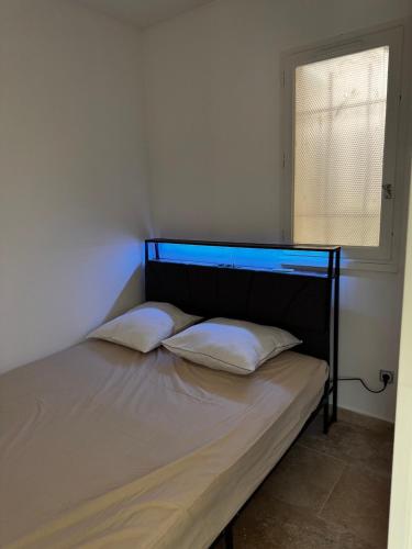 - un lit avec deux oreillers dans une chambre dotée d'une fenêtre dans l'établissement Furnished 2-room apartment with terrace, au Cap d'Agde