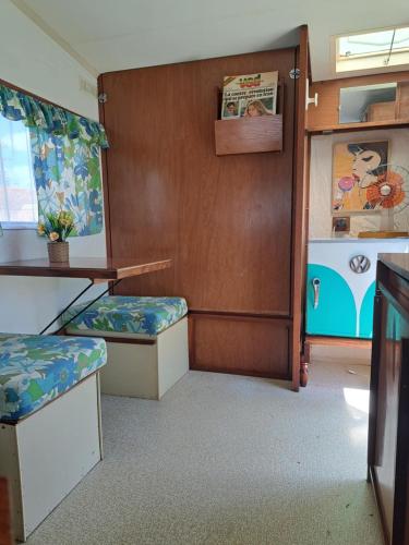 une salle de train avec deux sièges et une table et une table dans l'établissement Caravane 70's, à Saint-Marcet