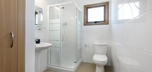 une salle de bain blanche avec toilettes et lavabo dans l'établissement Potamos Villa - Villa Kymma 4, à Ayia Napa