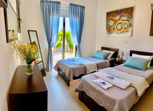 une chambre avec deux lits et une table et une fenêtre dans l'établissement Potamos Villa - Villa Kymma 4, à Ayia Napa