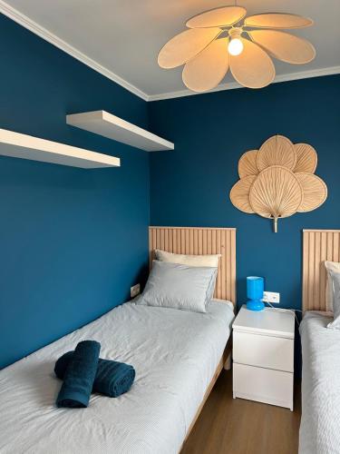 ein blaues Schlafzimmer mit einem Bett und einer blauen Wand in der Unterkunft Charming Penthouse - Sunny - Terrace - Close to Sea and Restaurants in Blankenberge