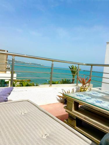 a patio with a table and a view of the ocean at Duplex Pieds dans L'eau in Douar el Hafey