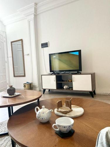 a living room with a tv and a coffee table at Duplex Pieds dans L'eau in Douar el Hafey