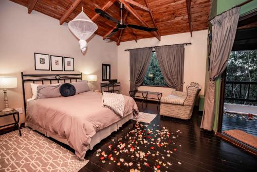 a bedroom with a bed and a large window at Thulamela Couples Retreat in Hazyview