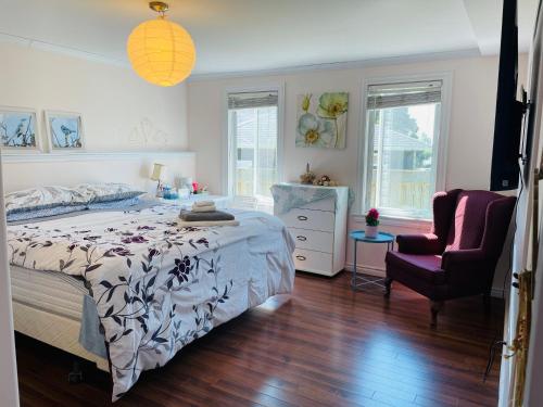 a bedroom with a bed and a chair at Lily's garden in Charlottetown