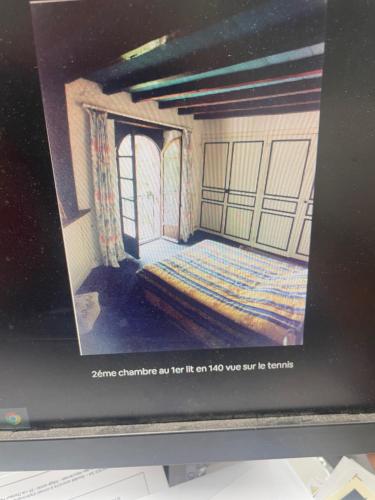une photo d'une pièce avec un lit sur un écran d'ordinateur dans l'établissement ecurie de bidalon, à La Celle-sous-Gouzon