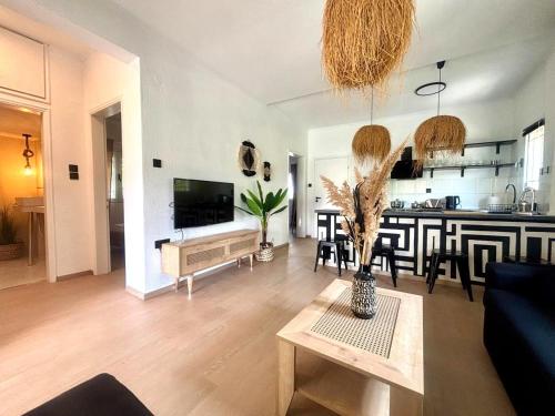 Una sala de estar con un sofá y una mesa y una cocina. en Ammo's Villa, en Orfánion