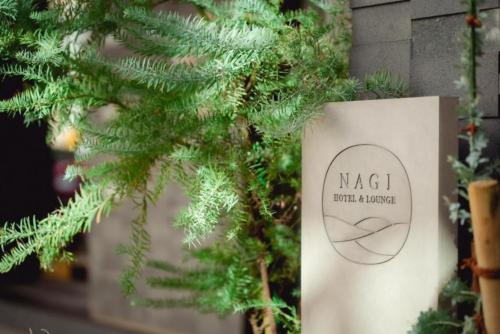 a christmas tree with a sign in front of it at NAGI Hiroshima Hotel and Lounge in Hiroshima
