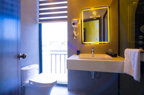 a bathroom with a sink and a toilet and a mirror at Phuc Hai Hotel Da Lat in Da Lat