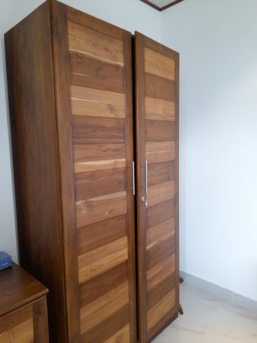 a wooden closet with wooden doors in a room at Cozy Nest Sri Lanka in Embilipitiya