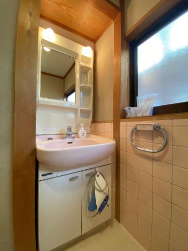 a bathroom with a sink and a mirror at Naoshima Haru House in Naoshima