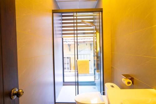 a bathroom with a toilet and a glass shower at Phuc Hai Hotel Da Lat in Da Lat