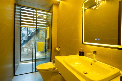 a bathroom with a sink and a toilet and a mirror at Phuc Hai Hotel Da Lat in Da Lat