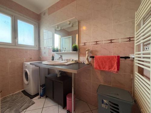une salle de bain avec un lavabo et une machine à laver dans l'établissement Haut de villa martigues, à Martigues