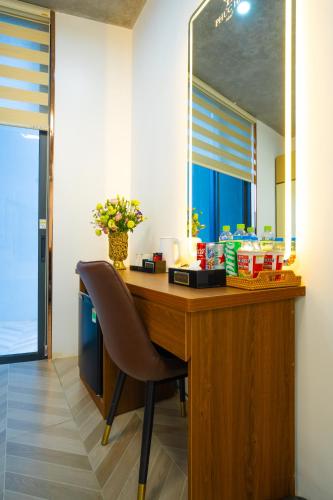 a desk with a chair in a room with a mirror at Phuc Hai Hotel Da Lat in Da Lat