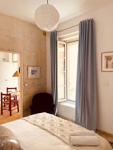 une chambre avec un lit, une fenêtre et une chaise dans l'établissement Mountado di Cabre hideout, à Arles