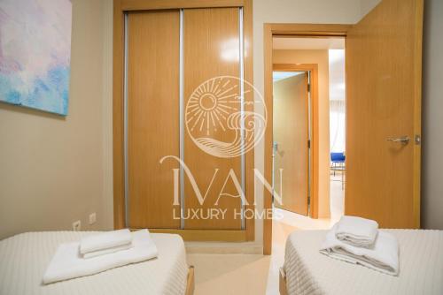 zwei Betten in einem Zimmer mit einem Schild an der Tür in der Unterkunft Casa Azul Ivan Luxury Homes 4ªPlta Norte 1ªLinea in Oropesa del Mar