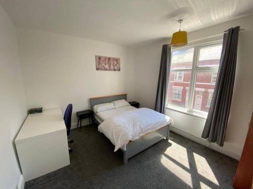a bedroom with a bed and a desk and a window at Cosy 2-Bed House - Sleeps 5 Garden & Pet-Friendly in Leicester