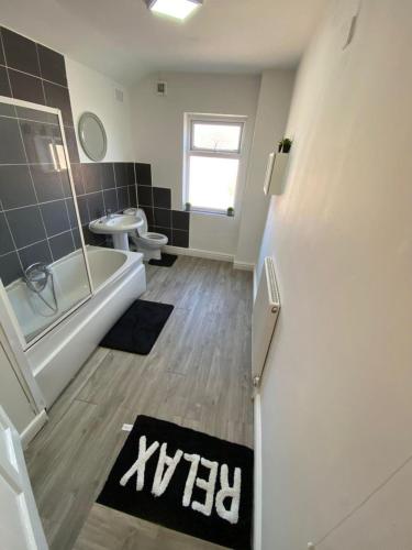 a bathroom with a tub and a toilet and a sink at Cosy 2-Bed House - Sleeps 5 Garden & Pet-Friendly in Leicester