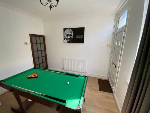 a green pool table in a room with a picture at Cosy 2-Bed House - Sleeps 5 Garden & Pet-Friendly in Leicester