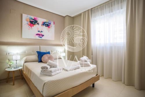 ein Schlafzimmer mit einem Bett und einem Gemälde an der Wand in der Unterkunft Casa Azul Ivan Luxury Homes 4ªPlta Norte 1ªLinea in Oropesa del Mar