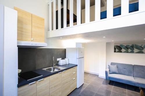 une cuisine avec un évier et un canapé dans une chambre dans l'établissement Cannes Sun, resid'appart, à Cannes