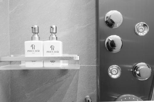two bottles ofodorizers on a shelf in a bathroom at Phuc Hai Hotel Da Lat in Da Lat