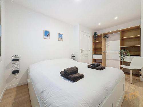 une chambre blanche avec un lit avec deux serviettes dessus dans l'établissement Bel appartement au Vallon des Auffes - Les Frères de la Loc', à Marseille