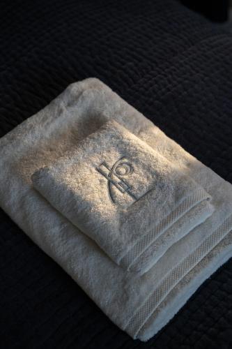 une pile de serviettes posée sur un lit dans l'établissement Le Chalet des Perchés, à Cadillac