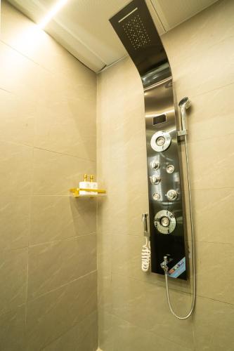 a bathroom with a shower with a clock on the wall at Phuc Hai Hotel Da Lat in Da Lat