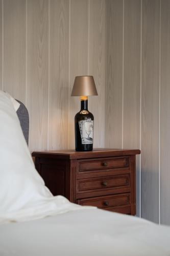 une lampe sur une table de nuit à côté d'un lit dans l'établissement Le Chalet des Perchés, à Cadillac