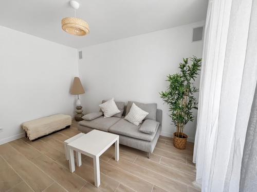 a living room with a couch and a table at Appartement lumineux et moderne, proche transports in Pantin