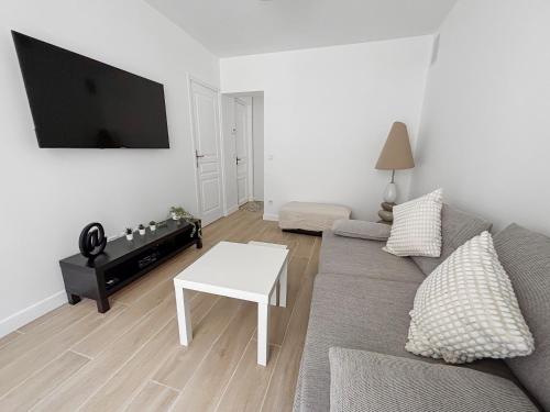 un salon avec un canapé et une table dans l'établissement Appartement lumineux et moderne, proche transports, à Pantin