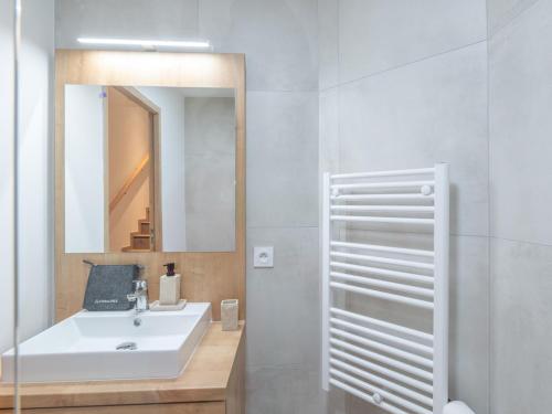 une salle de bain avec un lavabo blanc et un miroir dans l'établissement Appartement 2 chambres avec balcon au cœur de l'Alpe d'Huez - FR-1-645-85, à Huez