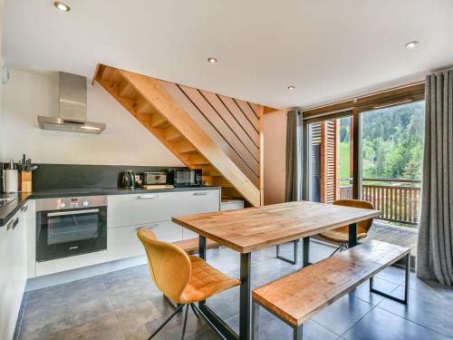 une cuisine avec une table et des chaises en bois dans l'établissement Appartement T4 - 6 à 8 pers - Les Gets, parking inclus - FR-1-685-87, aux Gets