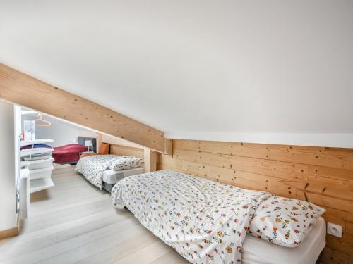 - 2 lits dans une chambre dotée de murs en bois dans l'établissement Appartement T4 - 6 à 8 pers - Les Gets, parking inclus - FR-1-685-87, aux Gets