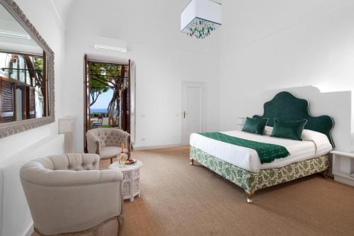 a bedroom with a bed and a couch and a chair at Villa Santa Caterina in Positano
