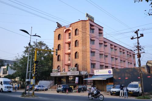 a pink building on the corner of a street at Sakthi Hotel in Pollāchi