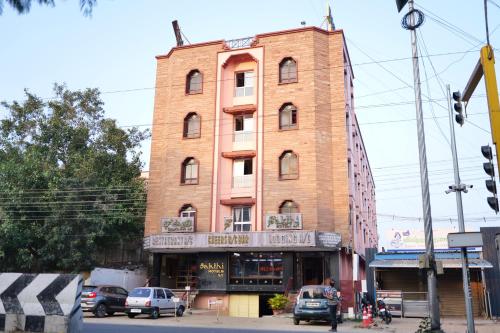 a tall brick building on the corner of a street at Sakthi Hotel in Pollāchi