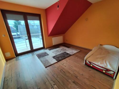 an empty room with a bed and a large window at Na Brzegu in Krempachy