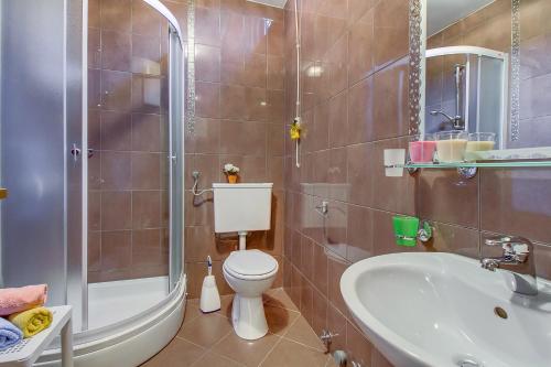 a bathroom with a toilet and a shower and a sink at Apartments Petra in Mali Lošinj