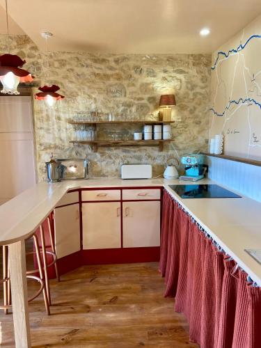a kitchen with a white counter top in a room at Maison as Cambous in Sauveterre-la-Lémance