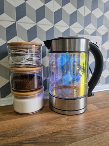 a food processor and a jar of spices on a counter at Bright and Cosy 2 bed House with free parking near the city centre in Central Station