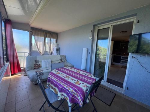 Un dormitorio con una cama y un televisor. en L'endroit, en La Seyne-sur-Mer