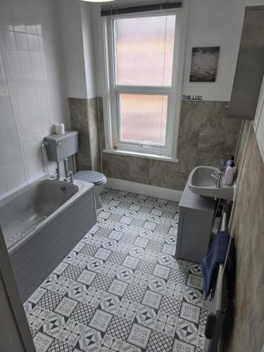 a bathroom with a tub and a toilet and a sink at Bright and Cosy 2 bed House with free parking near the city centre in Central Station