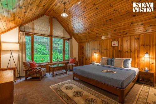 ein Schlafzimmer mit einem Bett in einem Holzzimmer in der Unterkunft StayVista at Retreat Cottages with Lawn, Bonfire in Manali