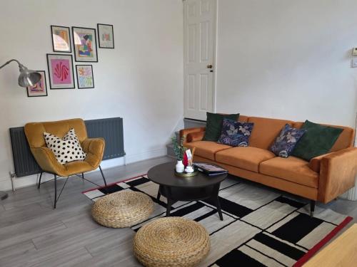 a living room with a couch and a table and chairs at Bright and Cosy 2 bed House with free parking near the city centre in Central Station