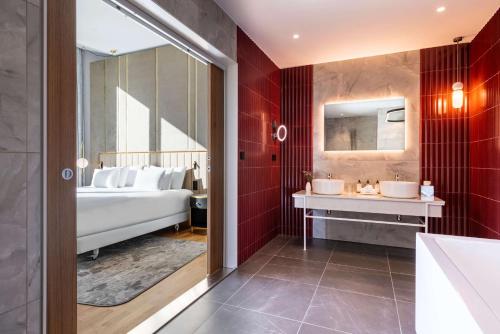 a bathroom with two sinks and a large mirror at NH Collection Copenhagen in Copenhagen