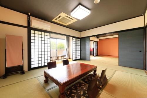 a dining room with a table and chairs and windows at Yutorelo Yamaga in Yamaga